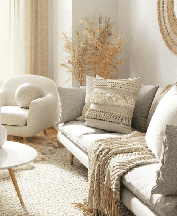 写真:白とベージュを基準とした家具が配置されている部屋のソファーとクッションが映っています