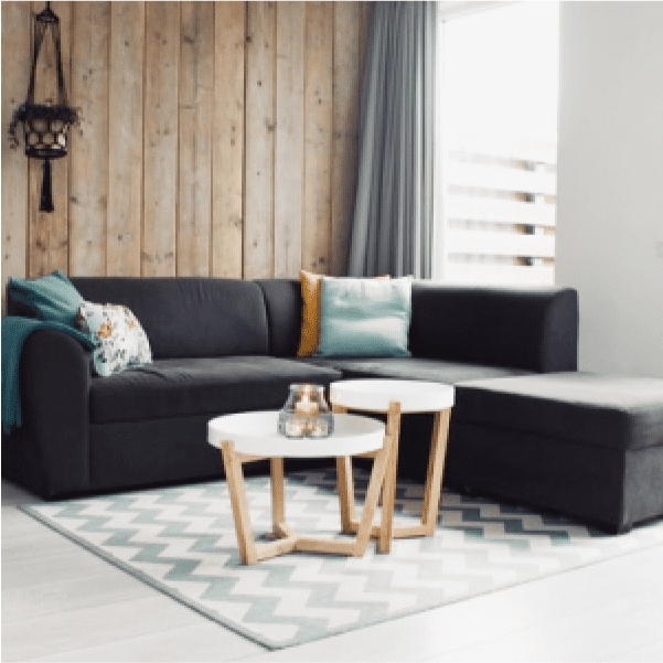 画像:グレーの大きなソファーと白を基調とした角ばった机があります